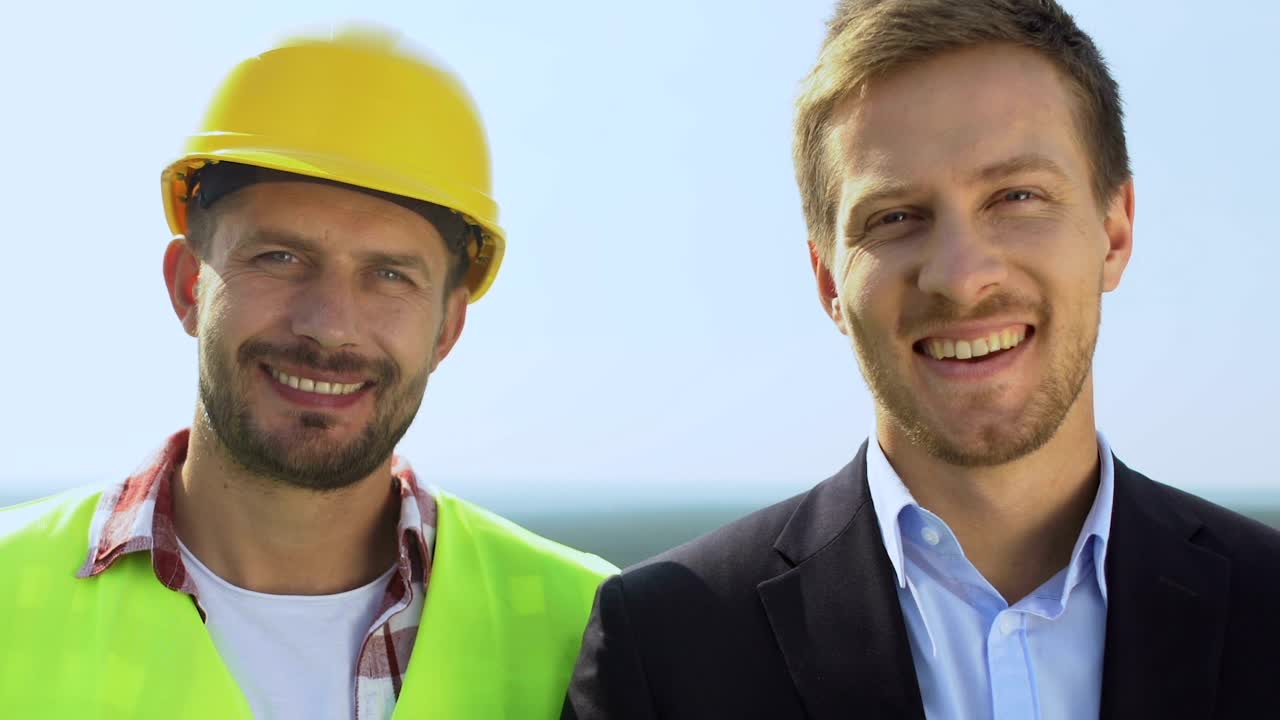 Tom Watson, a smiling builder in a yellow hard hat